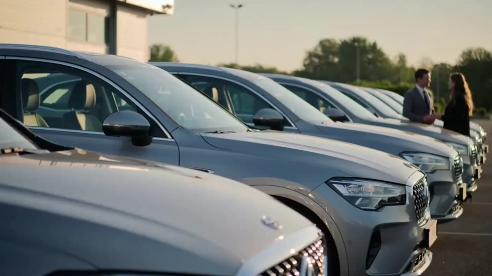 A row of hire cars lined up ready on a forecourt.